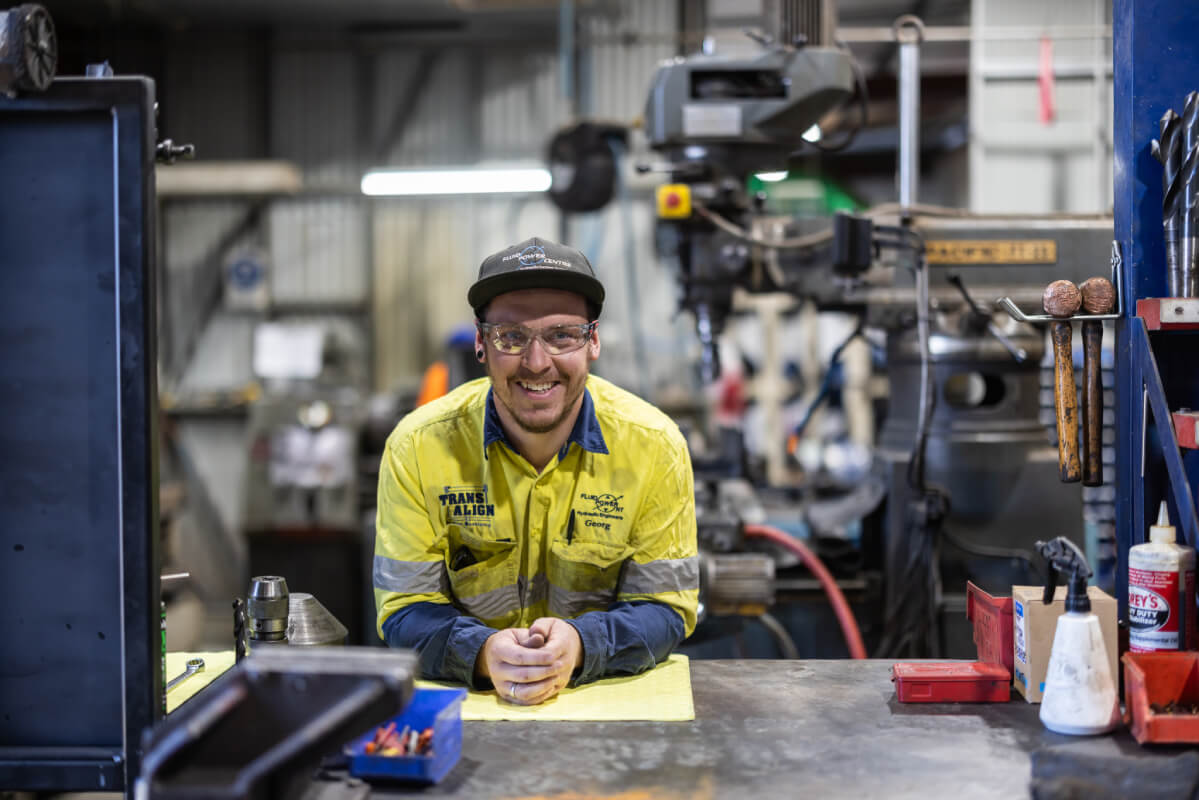 Smiling worker leaning on a workbench